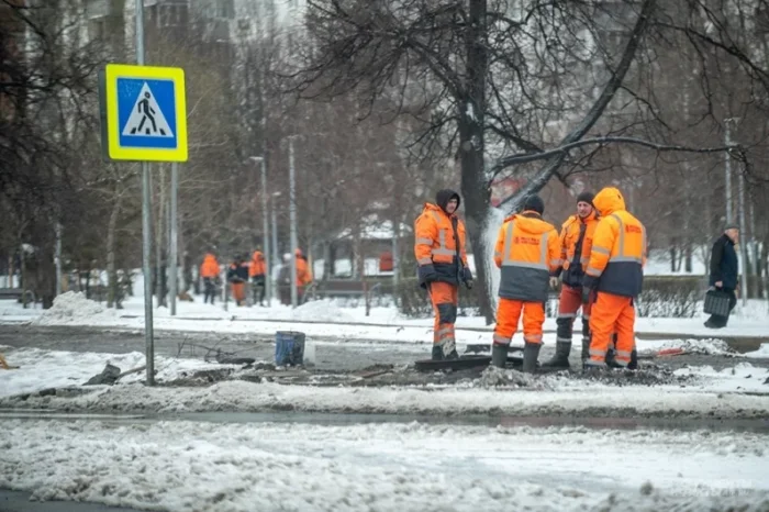 Рабочие чистят улицы от снега.